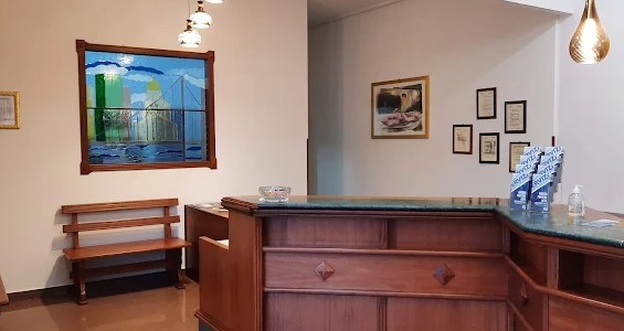 Bancone in legno con piano di marmo verde, panca e vetrata colorata con skyline cittadino in una sala d'attesa luminosa